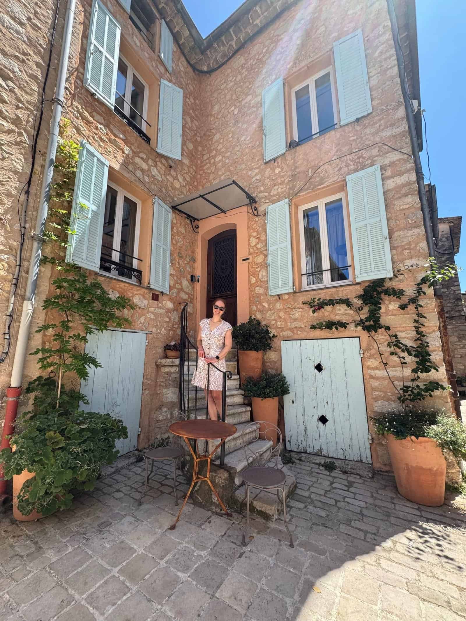 Woman_standing_in_front_of_stone_building_in_france